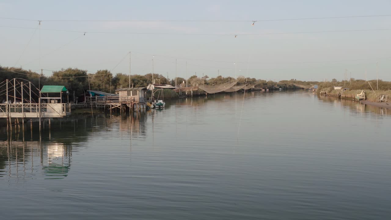 cabañas de pescadores con redes de pesca y equipos de pesca en el río por la mañana, lido di dante, fiumi uniti, ravenna cerca del valle de comacchio