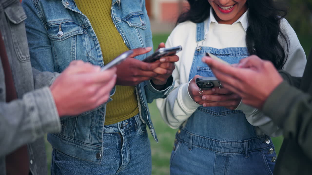 A group of friends using smartphones outdoors