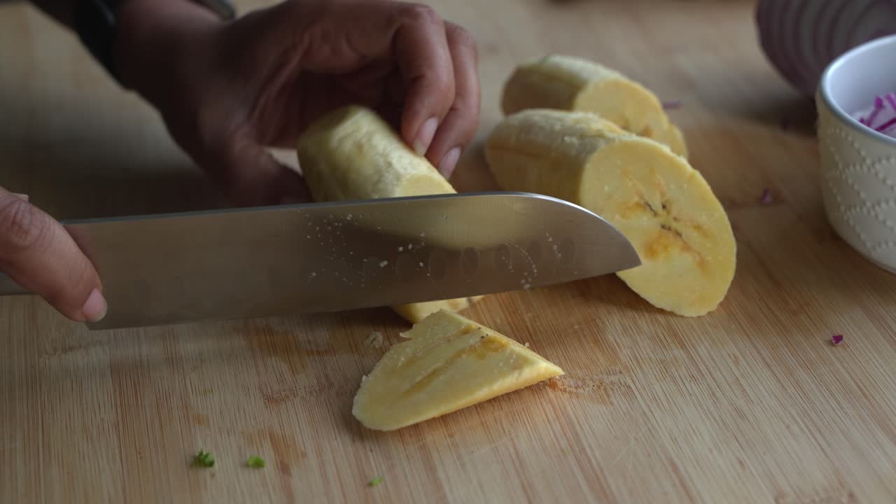 cortar pedazos de plátano amarillo e ingredientes especiales para cocinar una comida dos latas de frijoles arroz plátano aguacate cebolla roja y cilantro