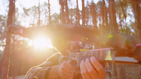 man aiming with compound bow in the forest 4k