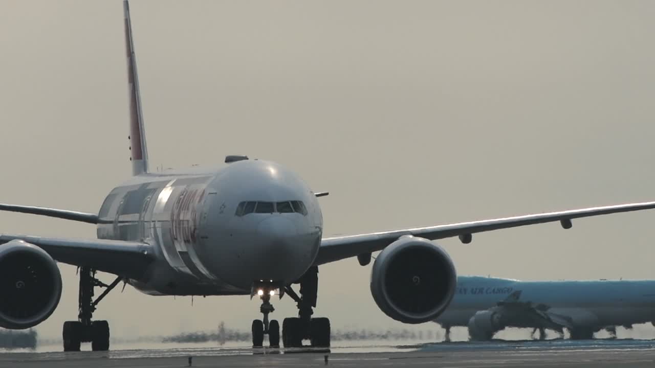 Swiss Airlines airplane slowly taxiing at airport with Korean Air in the background