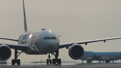 swiss airlines airplane slowly taxiing at airport with korean air in the background