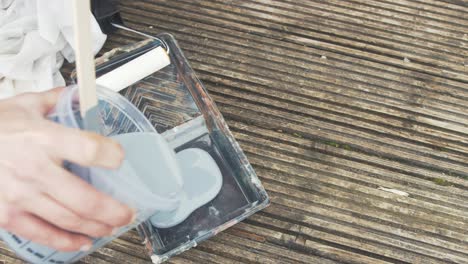 Pouring-grey-primer-paint-into-a-rolling-tray