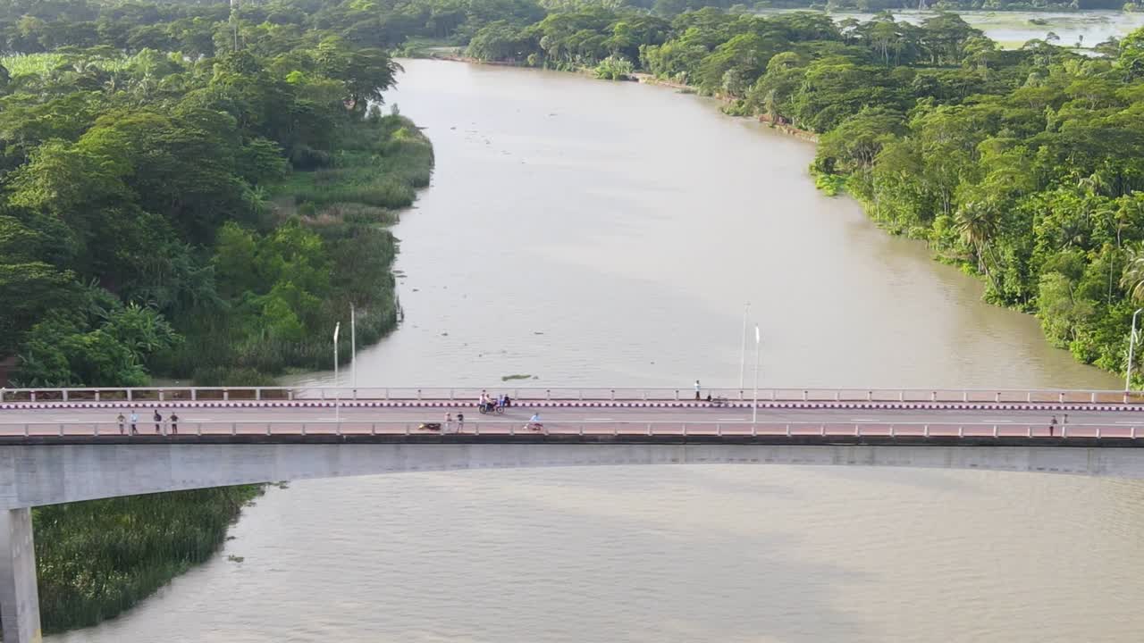 시골 방글라데시에서 강 위의 다리에서 자전거로 여행하는 모험