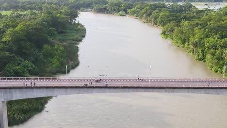 Adventure-traveling-by-bike-on-bridge-over-a-river-in-rural-Bangladesh