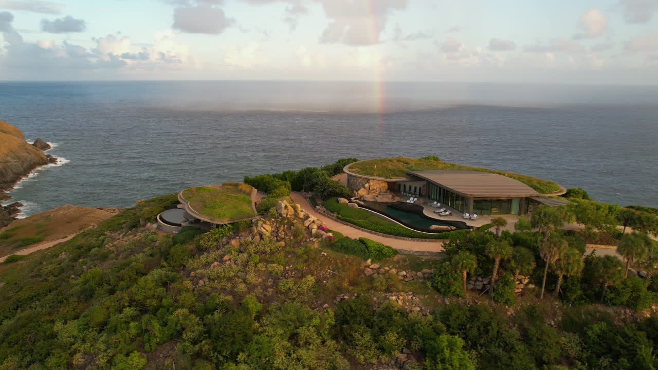 카리브 해 위 에 있는 현대적 인 언덕 꼭대기 잔디 지붕 빌라 와 무지개 의 공중 사진, 파노라마 드론  ⁇