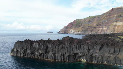 Drone-Ascendente-En-Rocas-Volcánicas-Con-Estructura-Oscura-En-Ponta-Da-Ferraria,-Azores