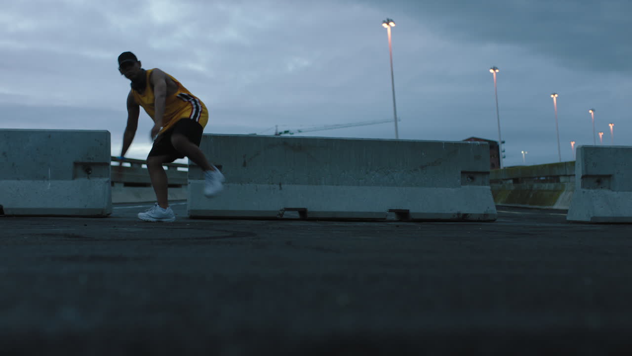 hombre bailando joven bailarín de break realizando movimientos modernos de baile de hip hop practicando coreografía de estilo libre urbano en una ciudad urbana nublada