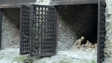 restos de esqueletos humanos cubiertos de ceniza volcánica dentro de los cobertizos de barcos de la antigua ciudad arqueológica romana de herculano.