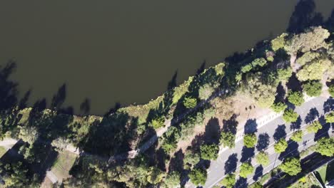 vista aérea de una carretera dividida en un suburbio australiano luego volando sobre un lago artificial