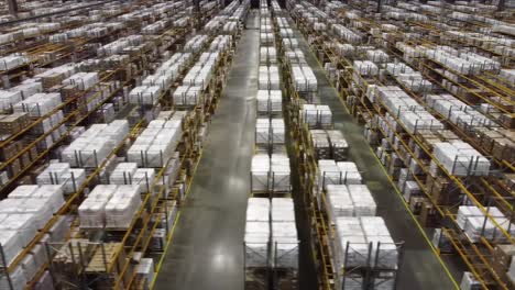 a vast storage warehouse contains rows upon rows of neatly stacked pallets. each pallet is carefully arranged, showcasing efficient organization and space management.