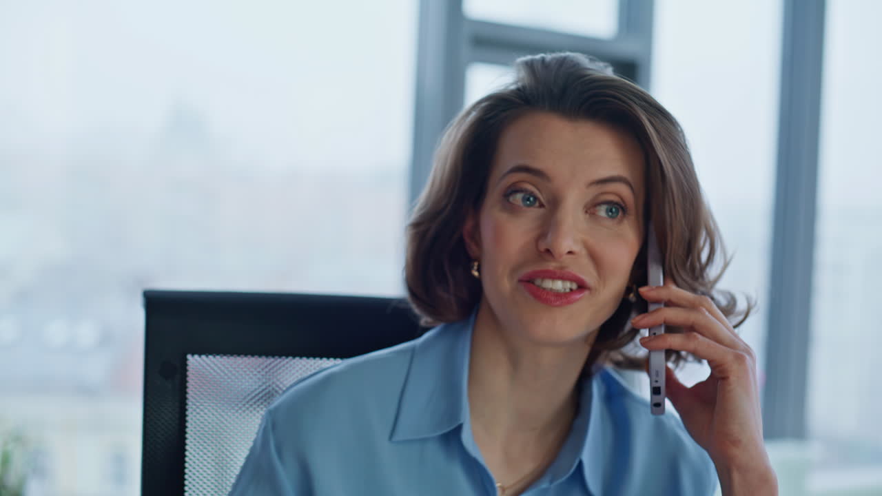 Retrato de uma alegre empresária fazendo uma ligação em seu celular no local de trabalho da empresa