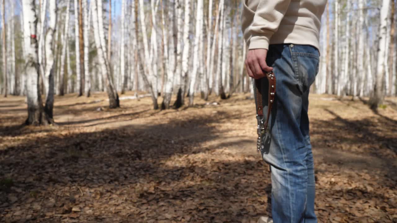 Mand går tur i en skov med en hund