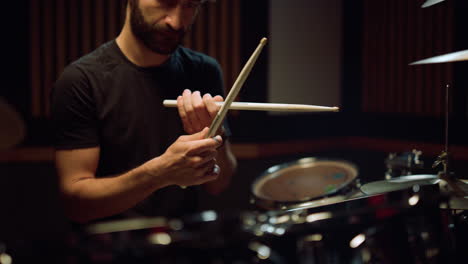 Artist-preparing-to-concert-in-hall.-Musician-hitting-drumsticks-in-studio.