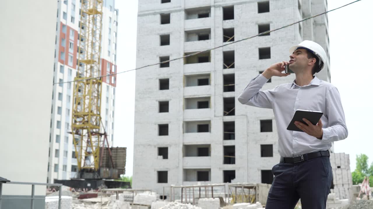 ingeniero hombre con tableta hablando en teléfono móvil y comprobando el proceso de tecnología de construcción