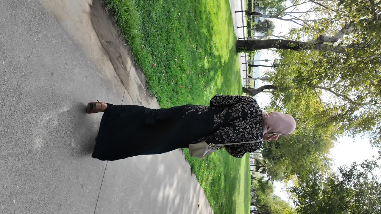 En kvinde med hijab, der går i en park
