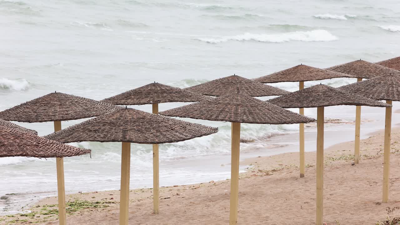 paisaje tranquilo con sombrillas de mimbre y olas del océano - estático