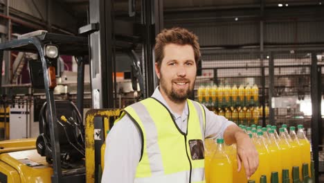 retrato de un trabajador de pie junto a la línea de producción