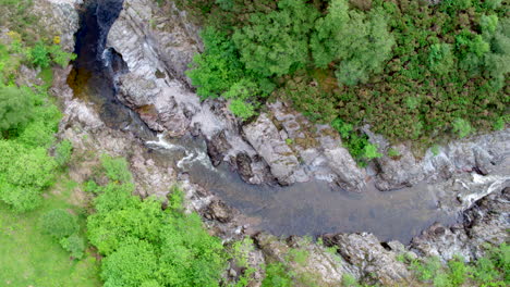 Video-De-Un-Dron-De-Arriba-Hacia-Abajo-De-Un-Río-Que-Fluye-A-Través-De-Un-Desfiladero-Bordeado-De-árboles-Con-Cascadas