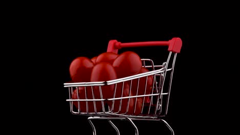 macro disparo de un carrito de supermercado lleno de tomates de cereza roja. girando en la mesa giratoria. aislado en el fondo negro. primer plano.