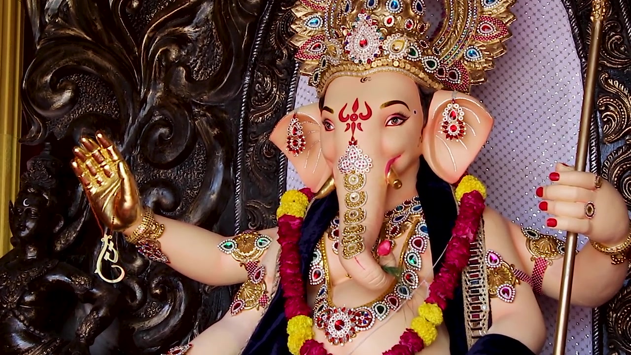 Busto della statua di Ganesha che mostra la mano benedicente, braccialetti dorati e ghirlande di calendula, festival di Ganesh Chaturthi, India