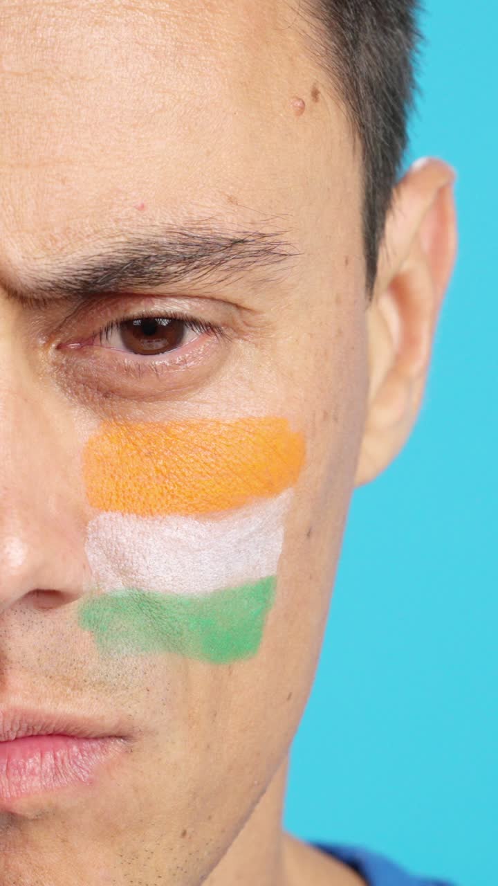 Serious man with a indian flag painted on the face