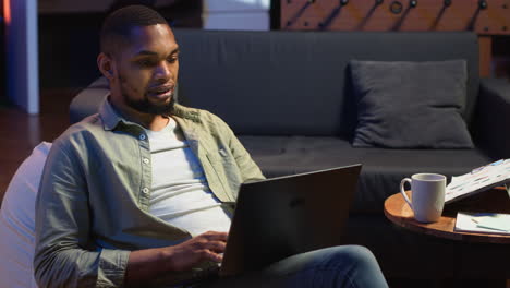 vertical video african american casual man solving daily tasks on his laptop at home
