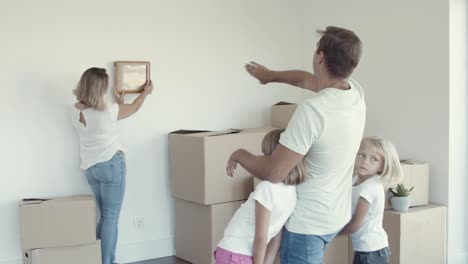 Dad-and-two-daughters-helping-mom-to-choose-place-for-picture