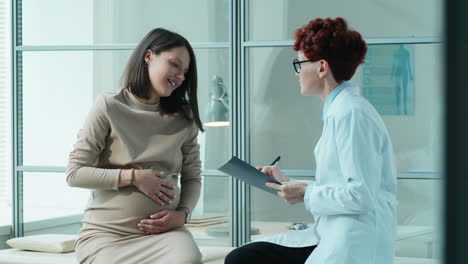 pregnant woman speaking with doctor during checkup in clinic