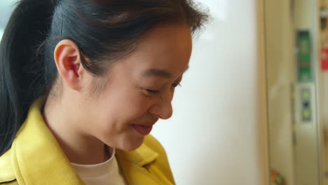 Close-Up-Of-Smiling-Young-Woman-Sitting-On-Underground-Train-On-Journey-To-Work-Or-Visiting-City