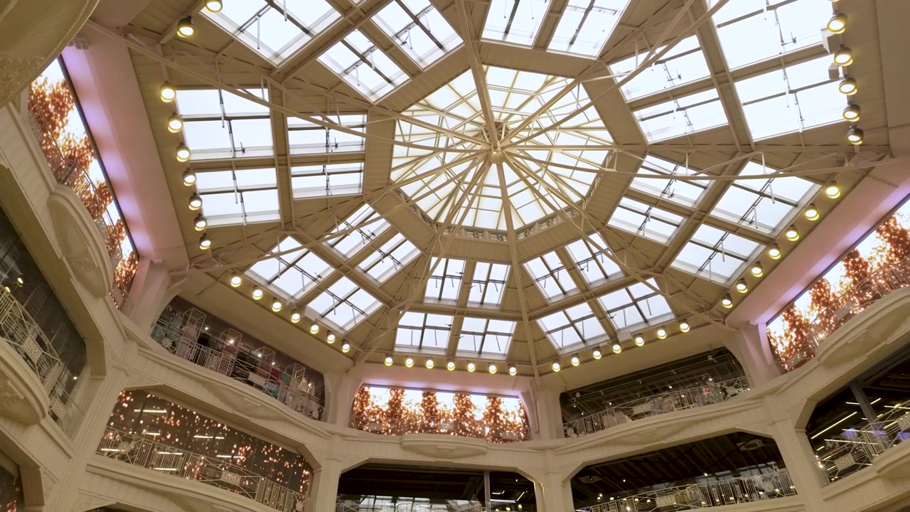Vista dal basso di uno splendido lucernario ottagonale in vetro e di un'architettura interna riccamente decorata di un centro commerciale di lusso a Madrid, Spagna. Adatto per contenuti di viaggio e design urbano.