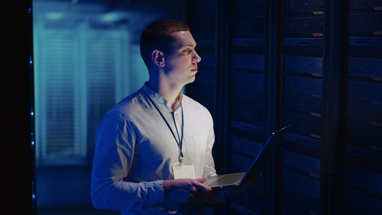 un joven trabaja en un centro de datos con bases de datos y equipos de pruebas