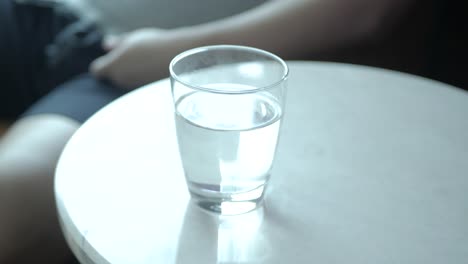 호텔 거실에서 휴식을 취하면서 마실 물 한 잔을 손에 들고 보기