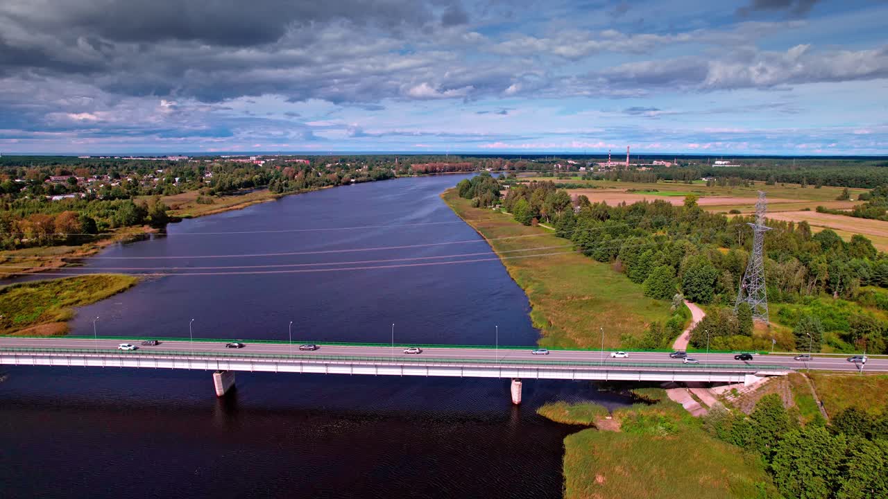 Beautiful aerial view of a river and bridge in Latvia under blue skies
