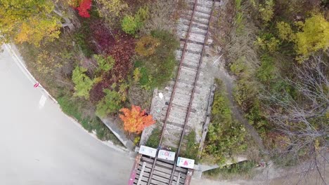 Toma-Aérea-Giratoria-De-Un-Antiguo-Puente-De-Tren-Durante-Los-Colores-Del-Otoño.