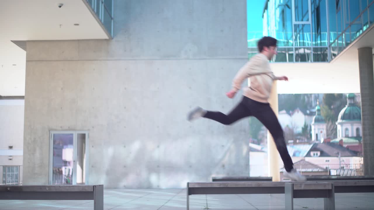 백인 젊은 성인이 파쿠르를 하고 벤치에서 벤치로 4k에 뛰어다니고 있습니다.