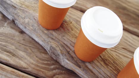 disposable cup in a row on wooden plank