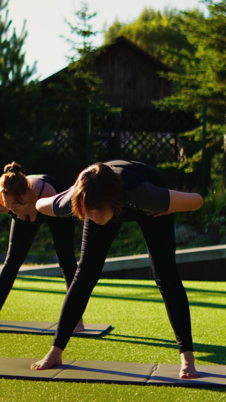Two Women Practicing Yoga Outdoors on Artificial Grass