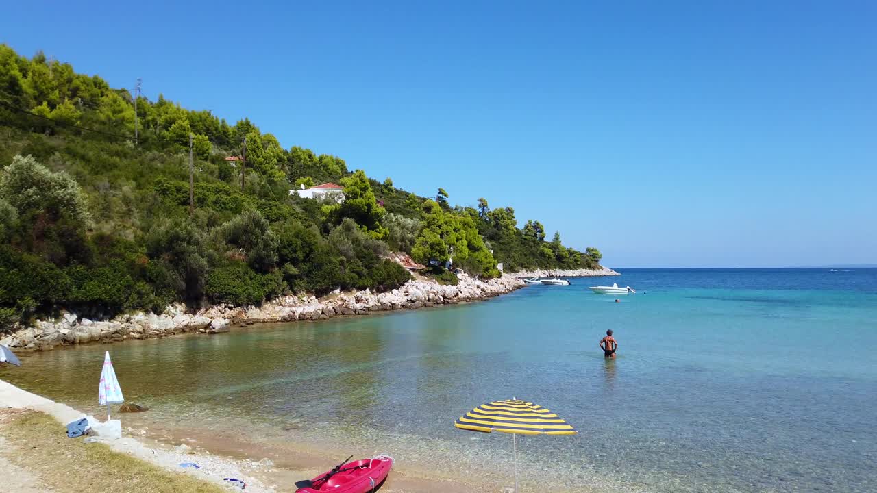Panning Shot Of A Stunning Beach And An Individual walking In The Sea At Naxos, Greece