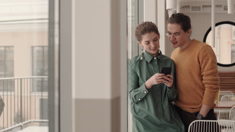 pareja usando un teléfono inteligente en un café