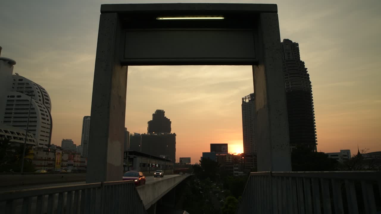 amanecer a través de un arco en la estación saphan taksin bts, bangkok, tailandia