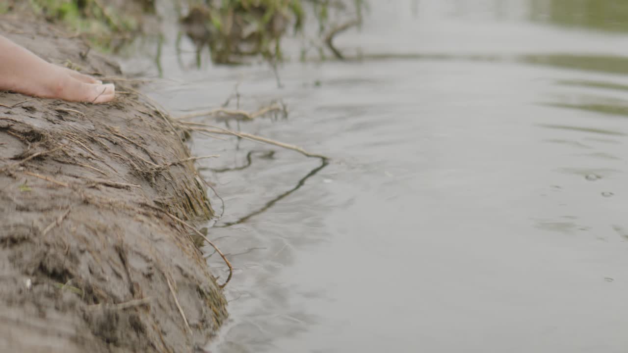 Gros plan sur des orteils plongeant dans une rivière.