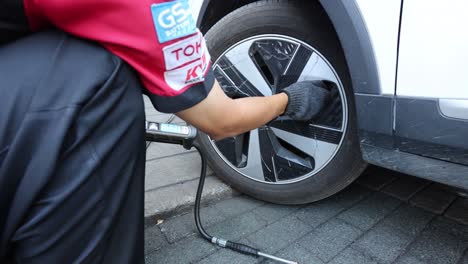 person cleaning and inspecting vehicle tire