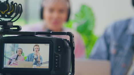 vista a través de la cámara de una pareja con auriculares vlogging transmisión en vivo riendo y hablando