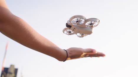 person holding a small white drone in hand