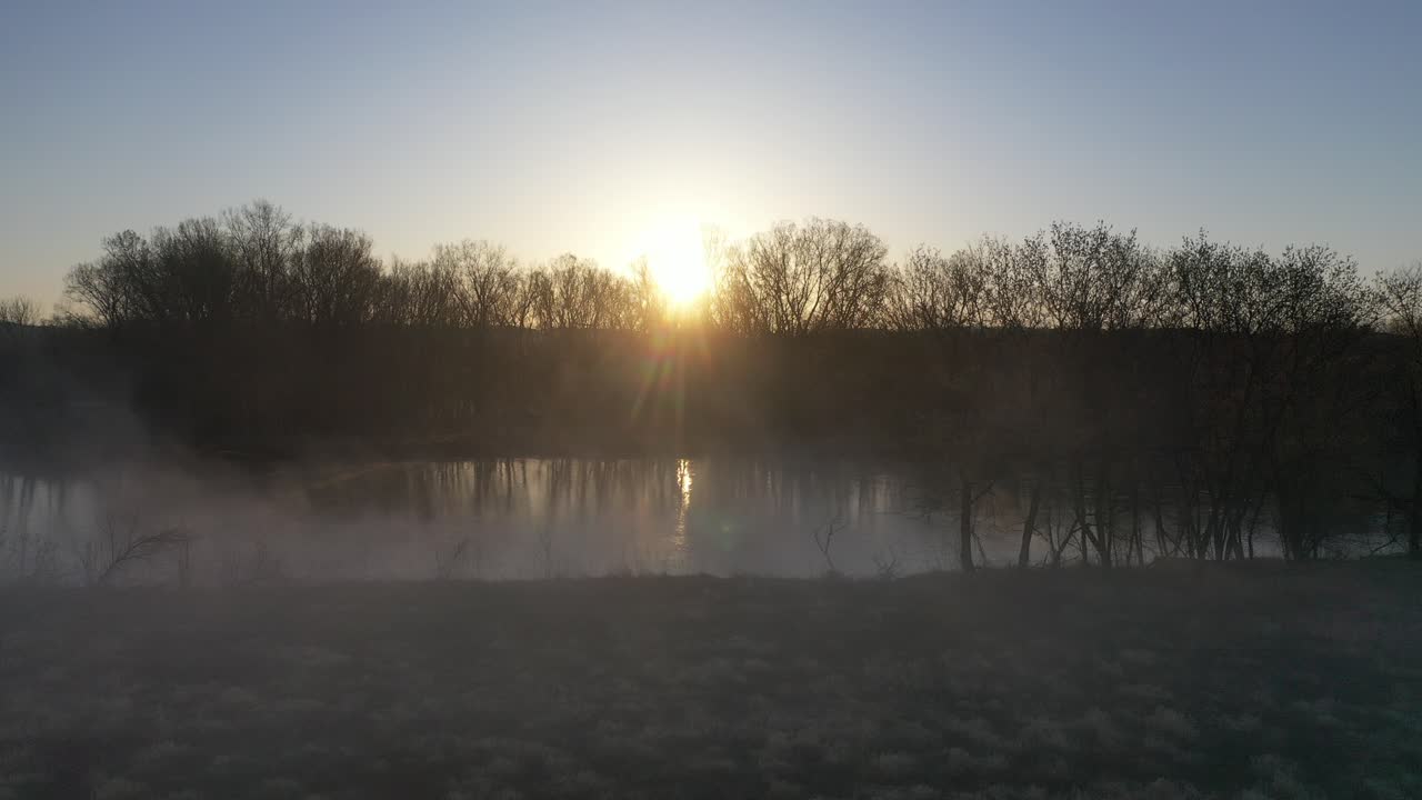 el amanecer sobre un paisaje de río brumoso