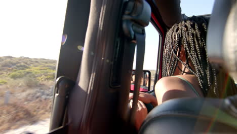 A-young-African-American-woman-enjoys-a-car-ride-on-a-road-trip,-with-copy-space