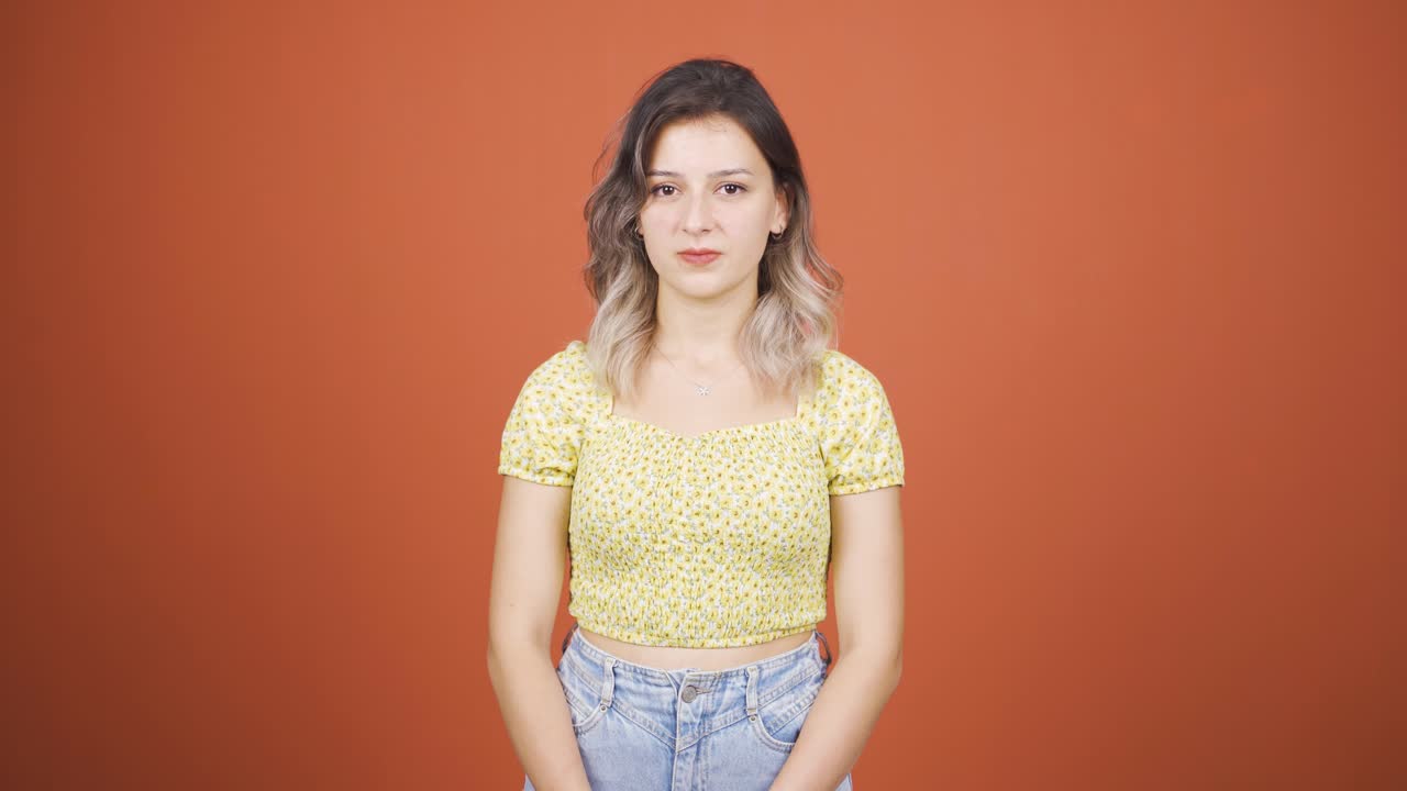 젊은 여성이 카메라를 향해 우울해 보입니다.