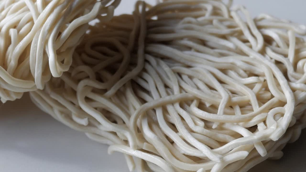 Close-up of wheat noodles, showcasing delicate, tangled strands in a soft light