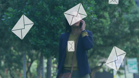 animation of mail message envelope isons over woman talking on smartphone